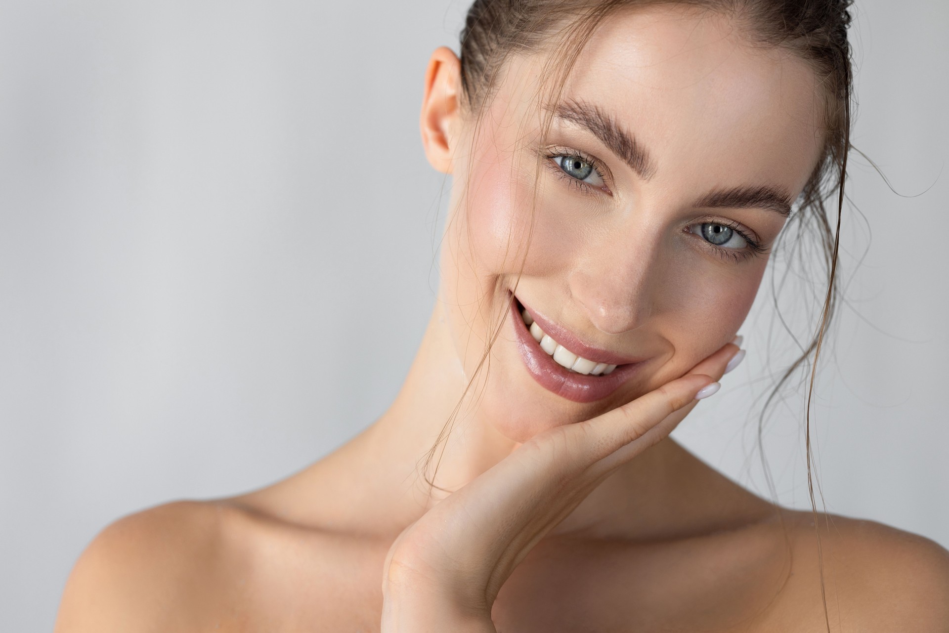 Young woman looking at camera with hand on chin
