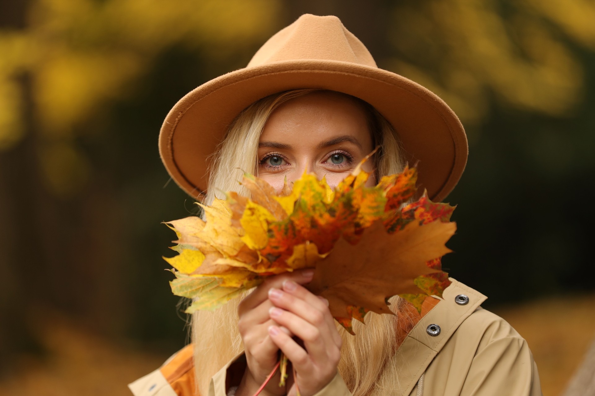 Portrait of beautiful woman with autumn leaves outdoors