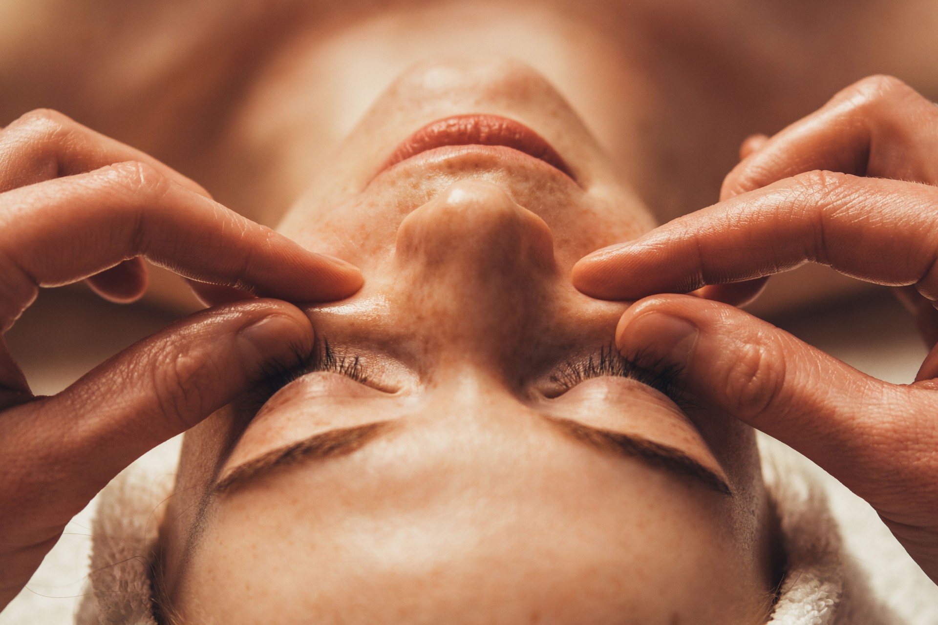 Close-up of a beautician's hands doing pinch and roll massage technique on womanâs face at spa salon. Beauty treatment. Beauty portrait. Healthy lifestyle. Cosmetic beauty spa salon.
